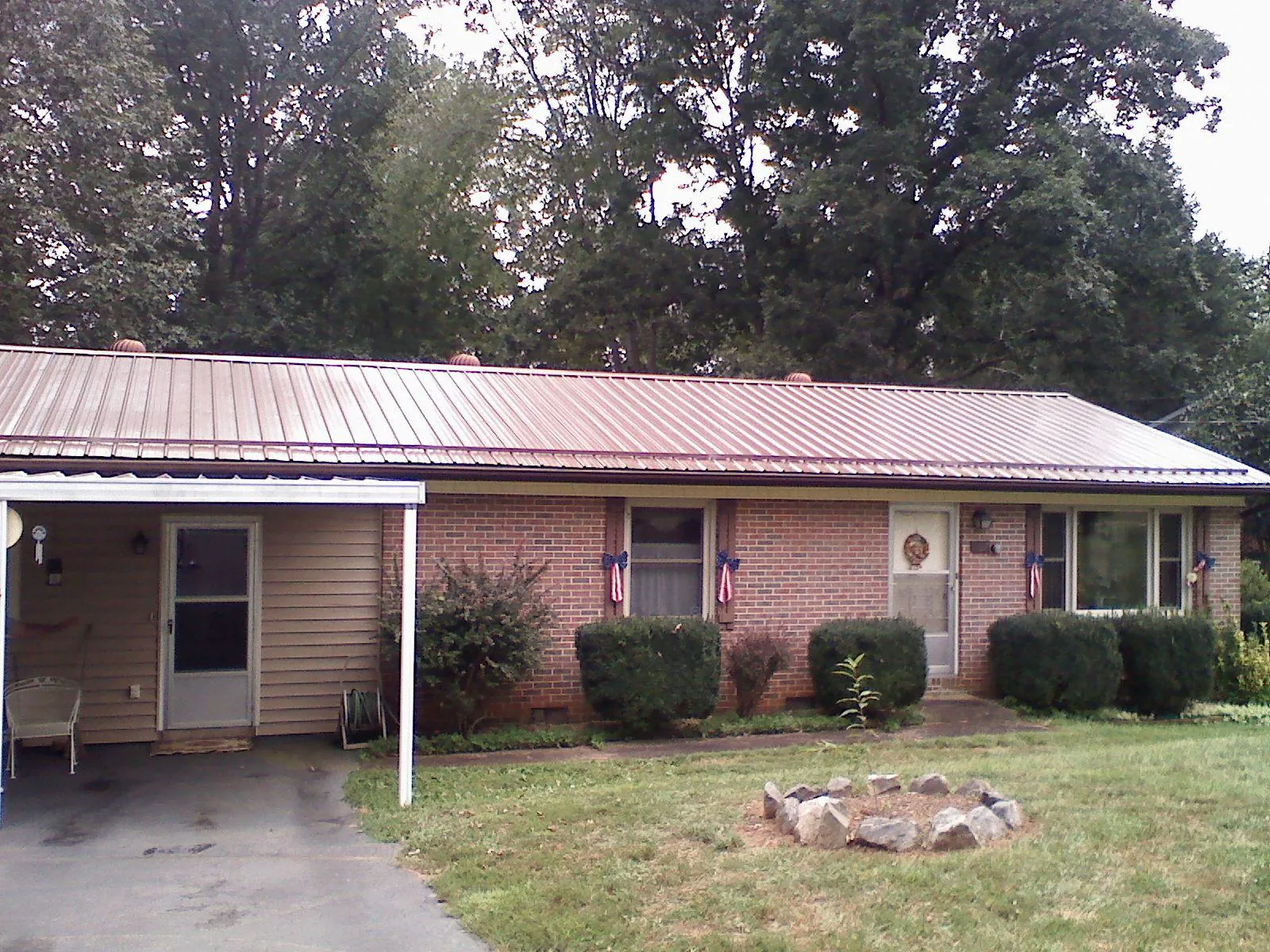 Bronze metal roof and carport on a brick ranch home — Roof Repair work by our crew in Montpelier